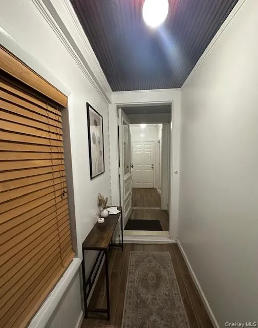 Hallway with ornamental molding and wood tiled floors Hallway with ornamental molding and wood tiled floors