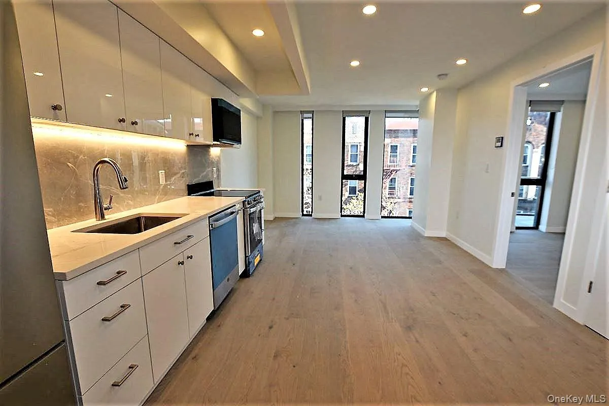 Kitchen featuring tasteful backsplash, appliances with stainless steel finishes, light wood finished floors, recessed lighting, and white cabinetry Kitchen featuring tasteful backsplash, appliances with stainless steel finishes, light wood finished floors, recessed lighting, and white cabinetry