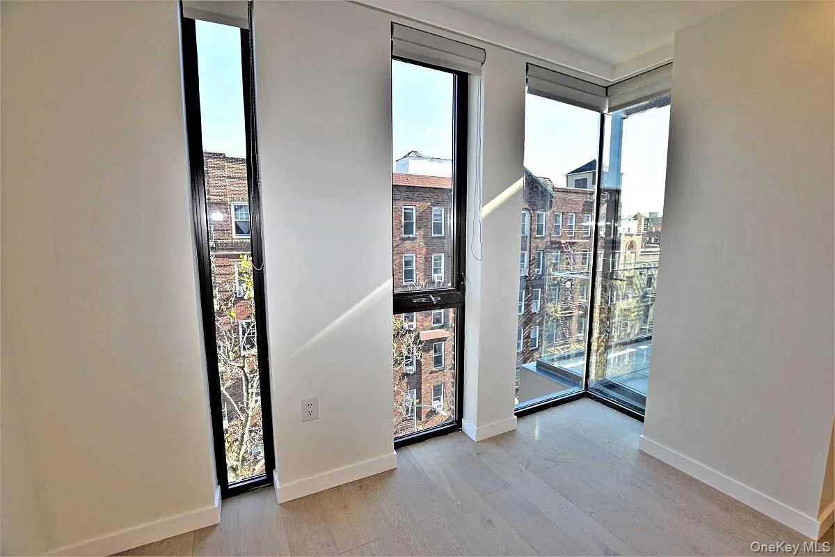 Empty room with plenty of natural light, light wood-type flooring, and a view of city Empty room with plenty of natural light, light wood-type flooring, and a view of city