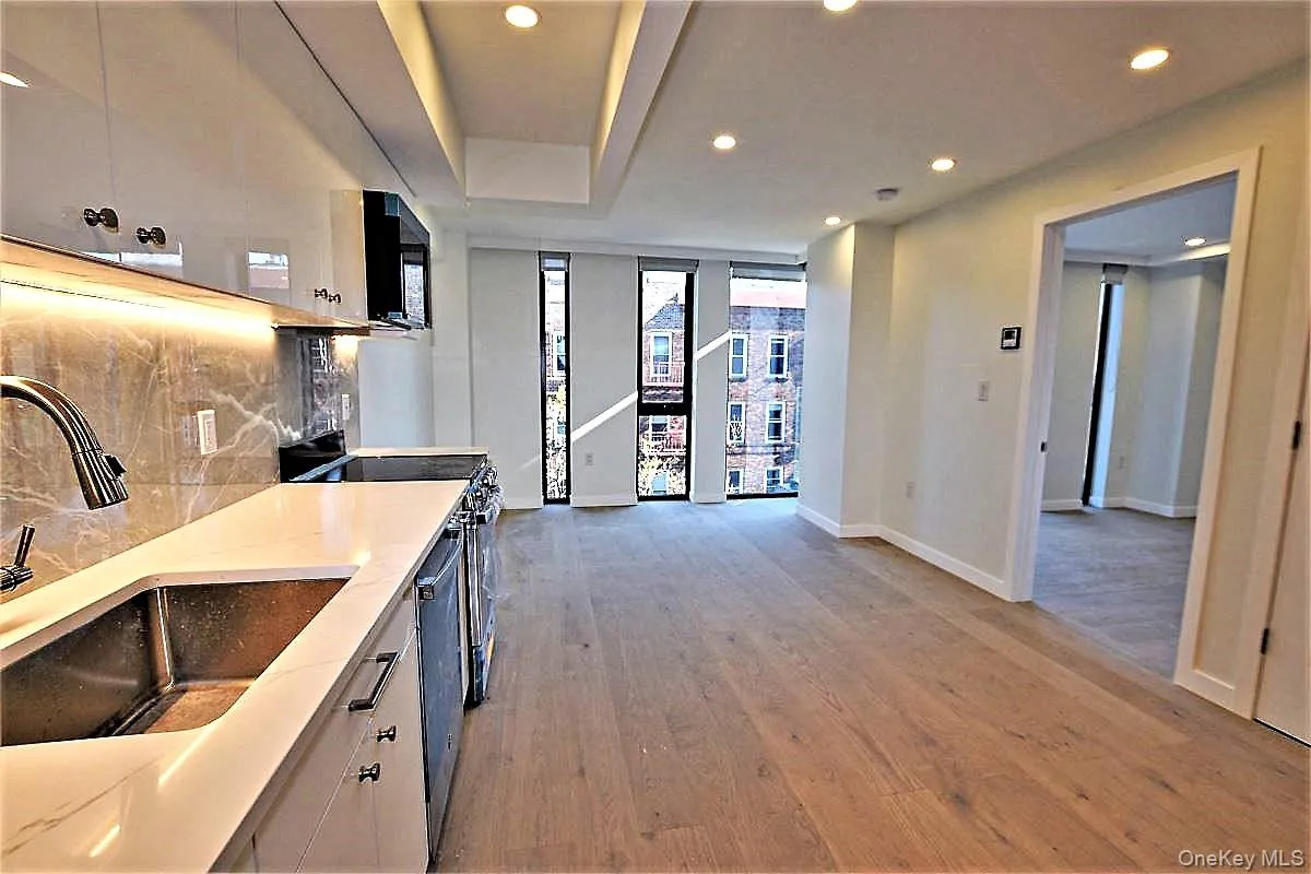 Kitchen featuring tasteful backsplash, recessed lighting, light wood-style floors, range with electric cooktop, and light stone countertops Kitchen featuring tasteful backsplash, recessed lighting, light wood-style floors, range with electric cooktop, and light stone countertops