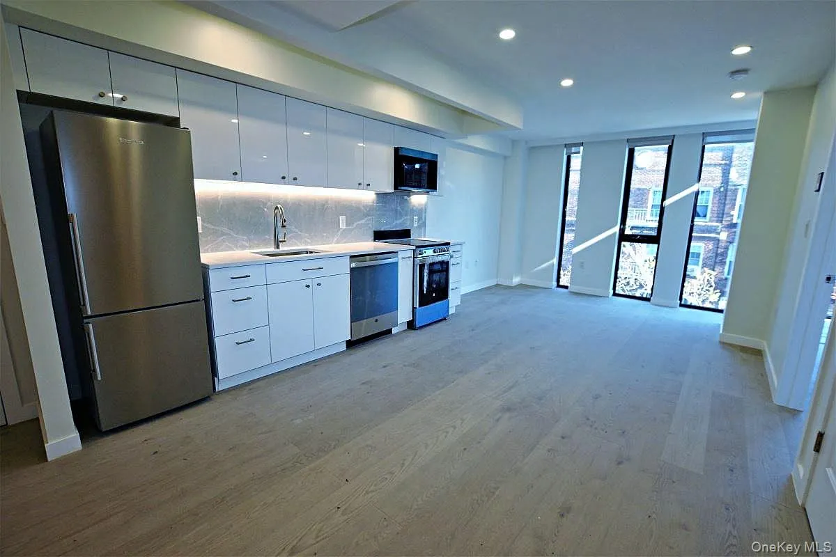 Kitchen with appliances with stainless steel finishes, light countertops, white cabinetry, tasteful backsplash, and light wood-type flooring Kitchen with appliances with stainless steel finishes, light countertops, white cabinetry, tasteful backsplash, and light wood-type flooring