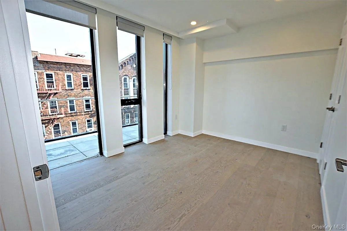 Unfurnished room featuring light wood-type flooring, recessed lighting, and floor to ceiling windows Unfurnished room featuring light wood-type flooring, recessed lighting, and floor to ceiling windows
