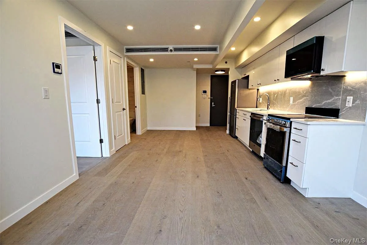 Kitchen featuring stainless steel appliances, light countertops, white cabinets, decorative backsplash, and recessed lighting Kitchen featuring stainless steel appliances, light countertops, white cabinets, decorative backsplash, and recessed lighting