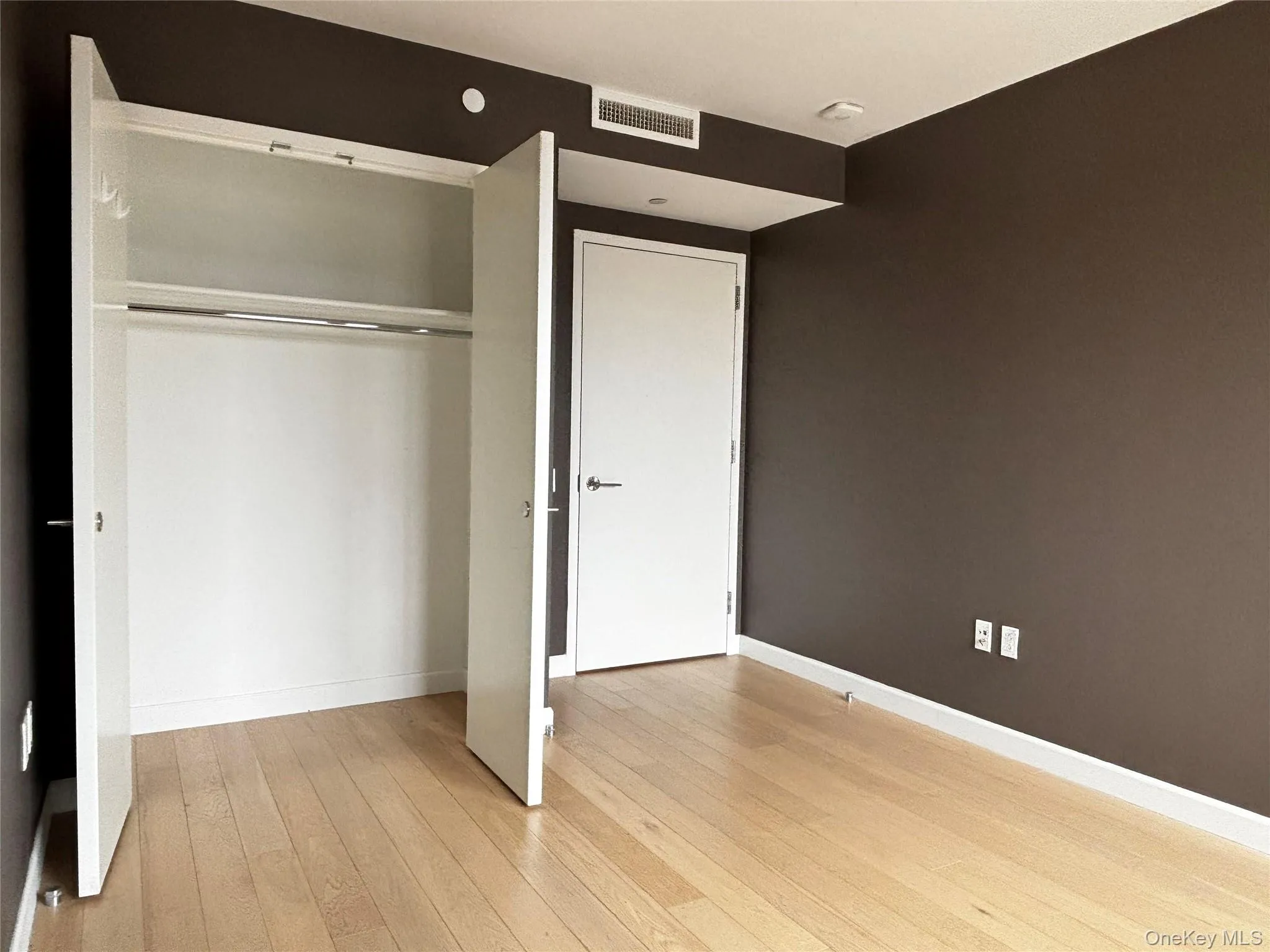 Unfurnished bedroom featuring light wood-style flooring and a closet Unfurnished bedroom featuring light wood-style flooring and a closet