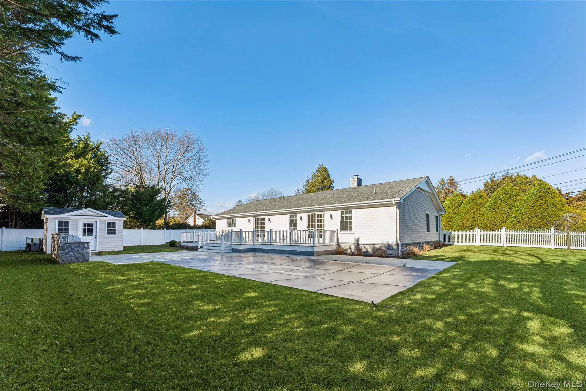 Fenced backyard featuring an outdoor shed, patio, deck off the back sliding glass doors, and an outdoor kitchen area. Fenced backyard featuring an outdoor shed, patio, deck off the back sliding glass doors, and an outdoor kitchen area.