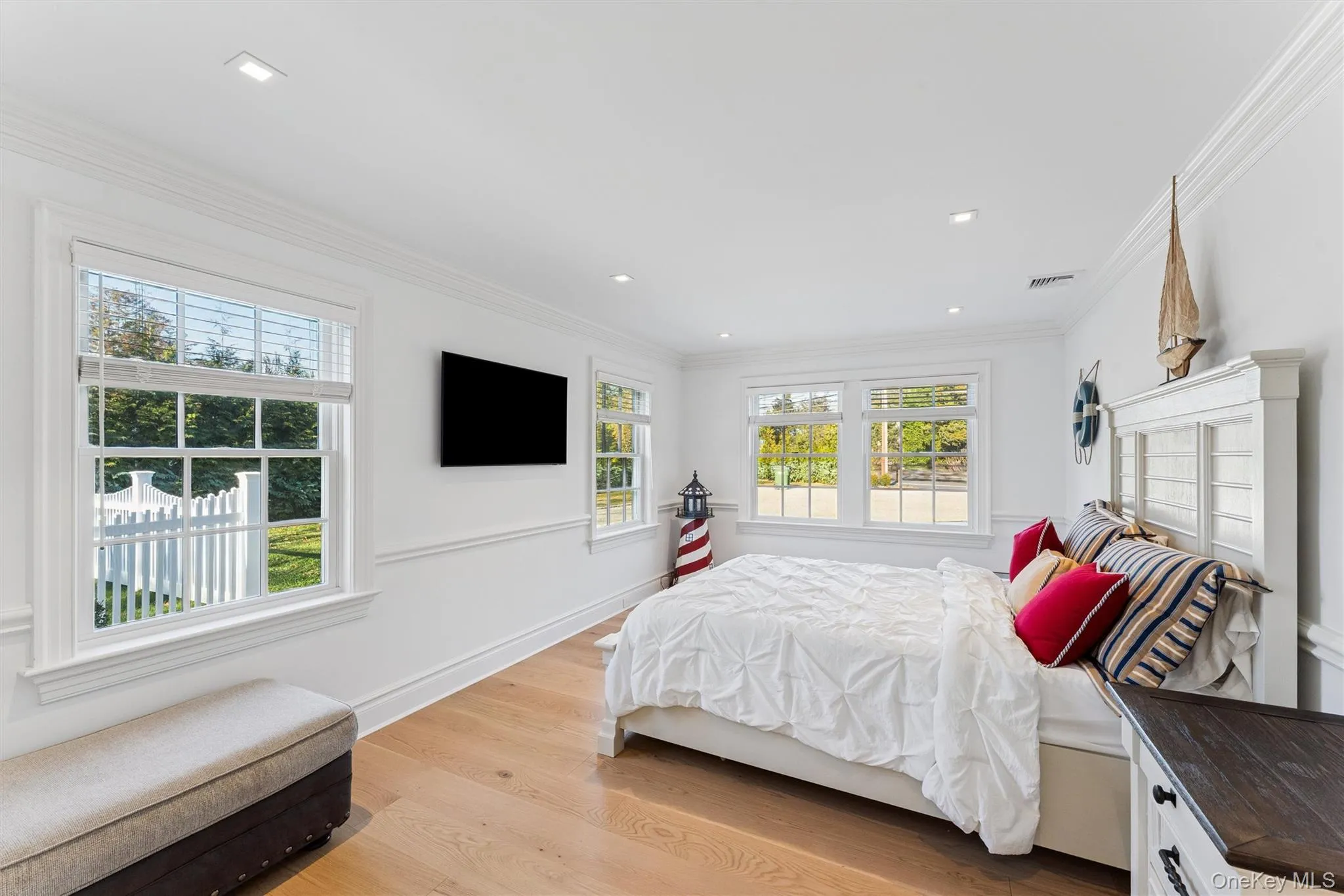 Bedroom with light wood floors and wainscoted walls. Bedroom with light wood floors and wainscoted walls.