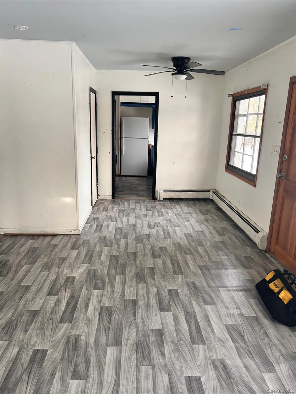 Unfurnished room featuring ceiling fan, a baseboard radiator, and light wood-type flooring Unfurnished room featuring ceiling fan, a baseboard radiator, and light wood-type flooring