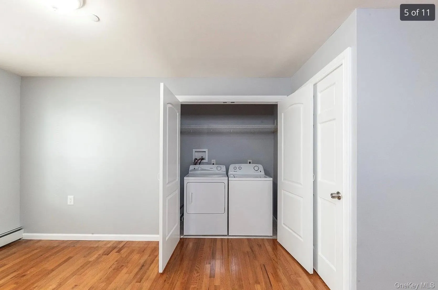 Washroom with washer and dryer and light wood-style flooring Washroom with washer and dryer and light wood-style flooring