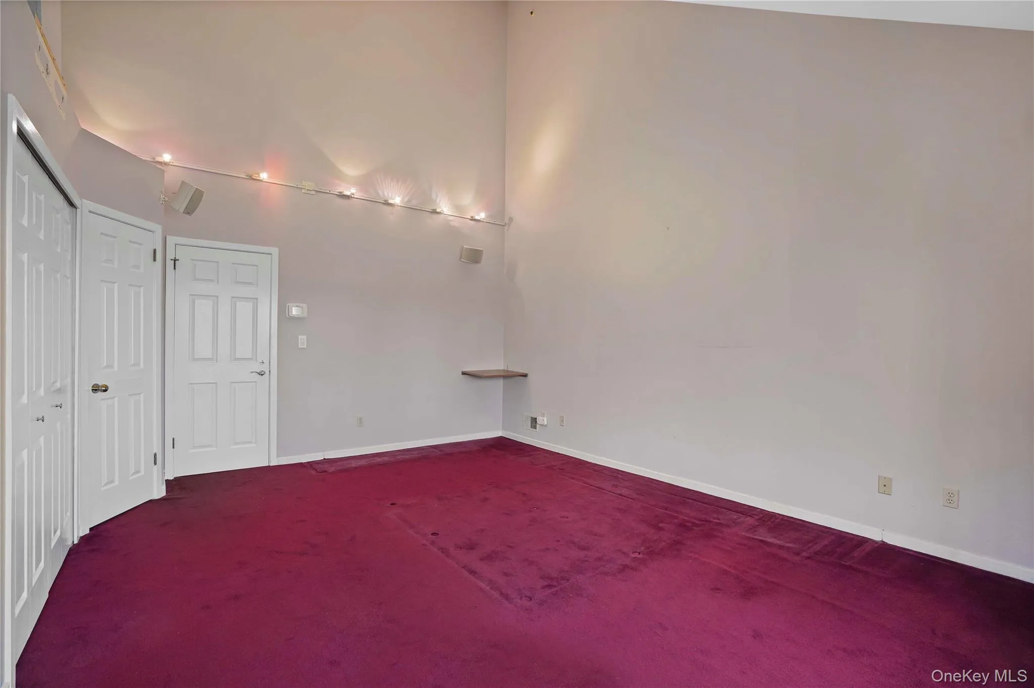 Unfurnished room featuring dark carpet and baseboards Unfurnished room featuring dark carpet and baseboards