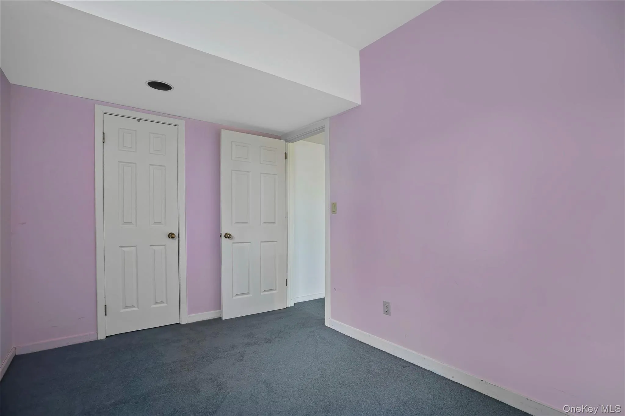 Unfurnished bedroom with dark carpet and a closet Unfurnished bedroom with dark carpet and a closet