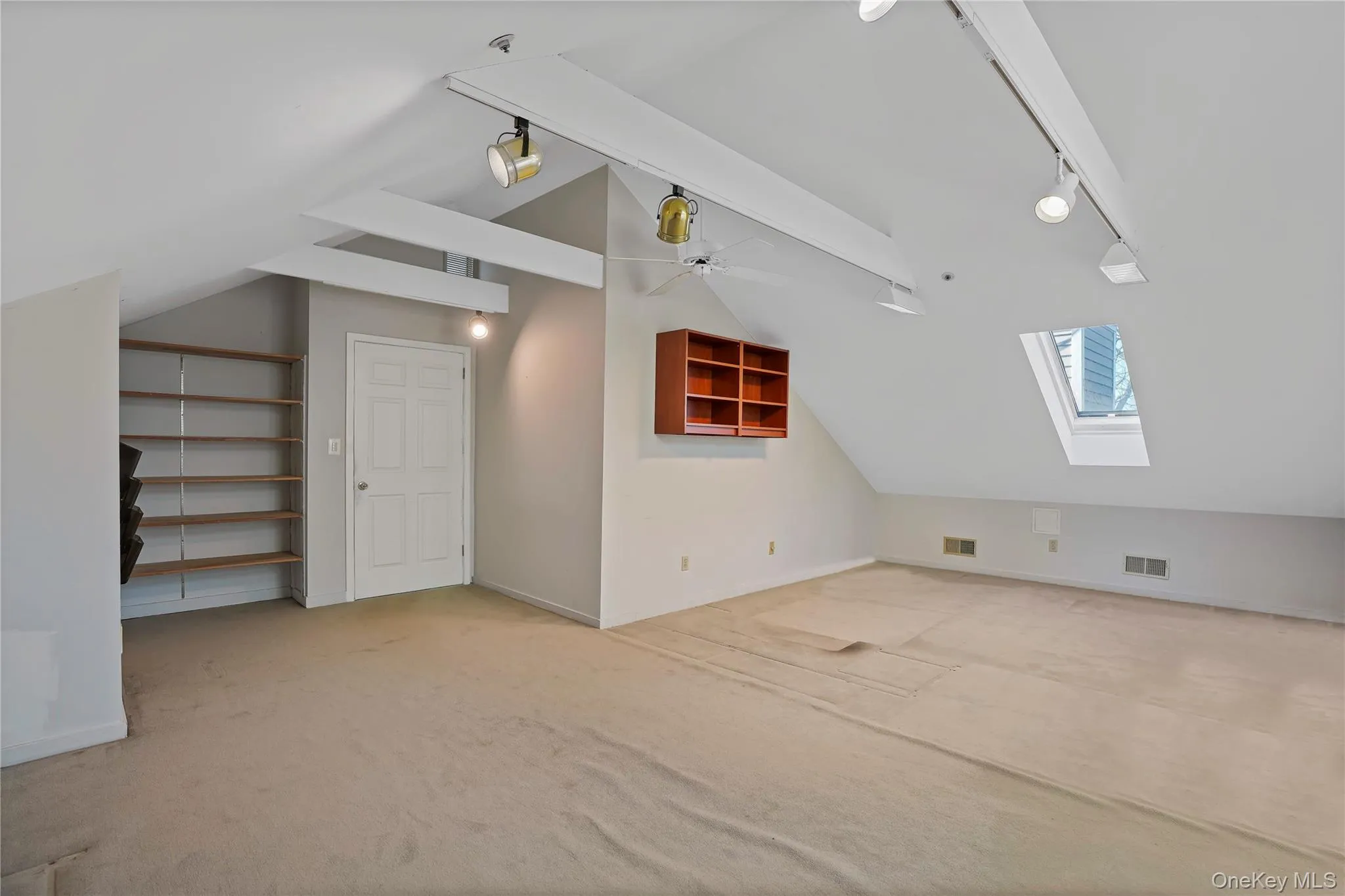 Additional living space featuring a skylight, lofted ceiling, and carpet floors Additional living space featuring a skylight, lofted ceiling, and carpet floors