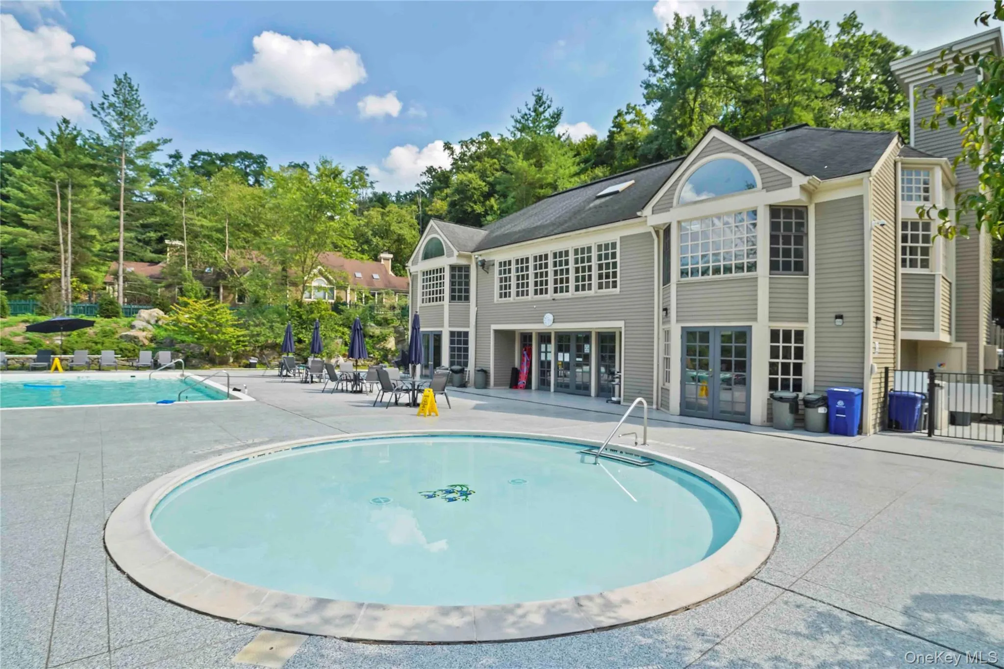 Community pool featuring a patio and view of wooded area Community pool featuring a patio and view of wooded area