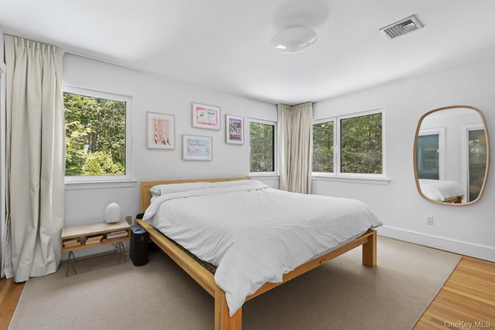 Bedroom featuring wood finished floors and multiple windows Bedroom featuring wood finished floors and multiple windows