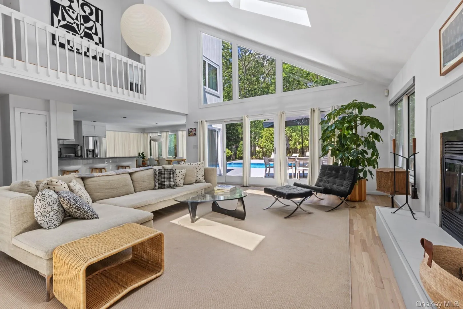 Living area with a skylight, wood finished floors, and a towering ceiling Living area with a skylight, wood finished floors, and a towering ceiling