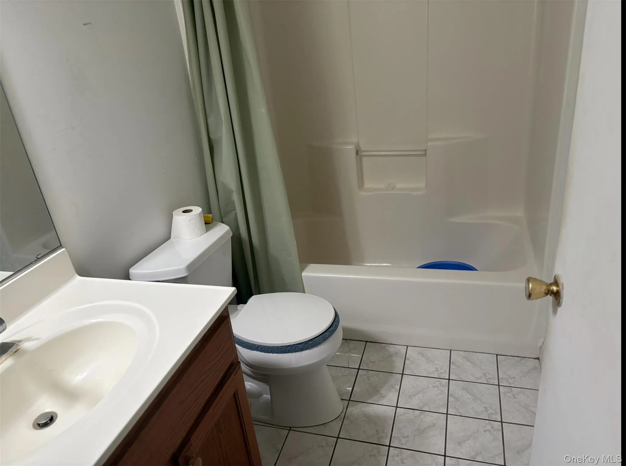 Bathroom featuring vanity, shower / bath combo with shower curtain, and light tile patterned floors Bathroom featuring vanity, shower / bath combo with shower curtain, and light tile patterned floors
