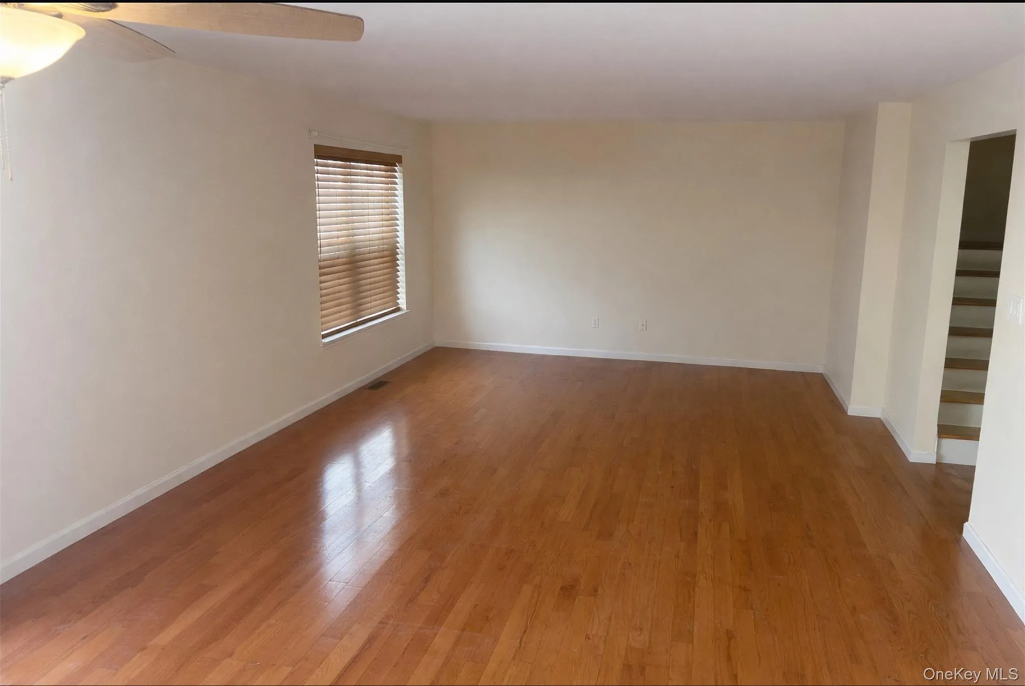 Empty room with light wood-type flooring and a ceiling fan Empty room with light wood-type flooring and a ceiling fan