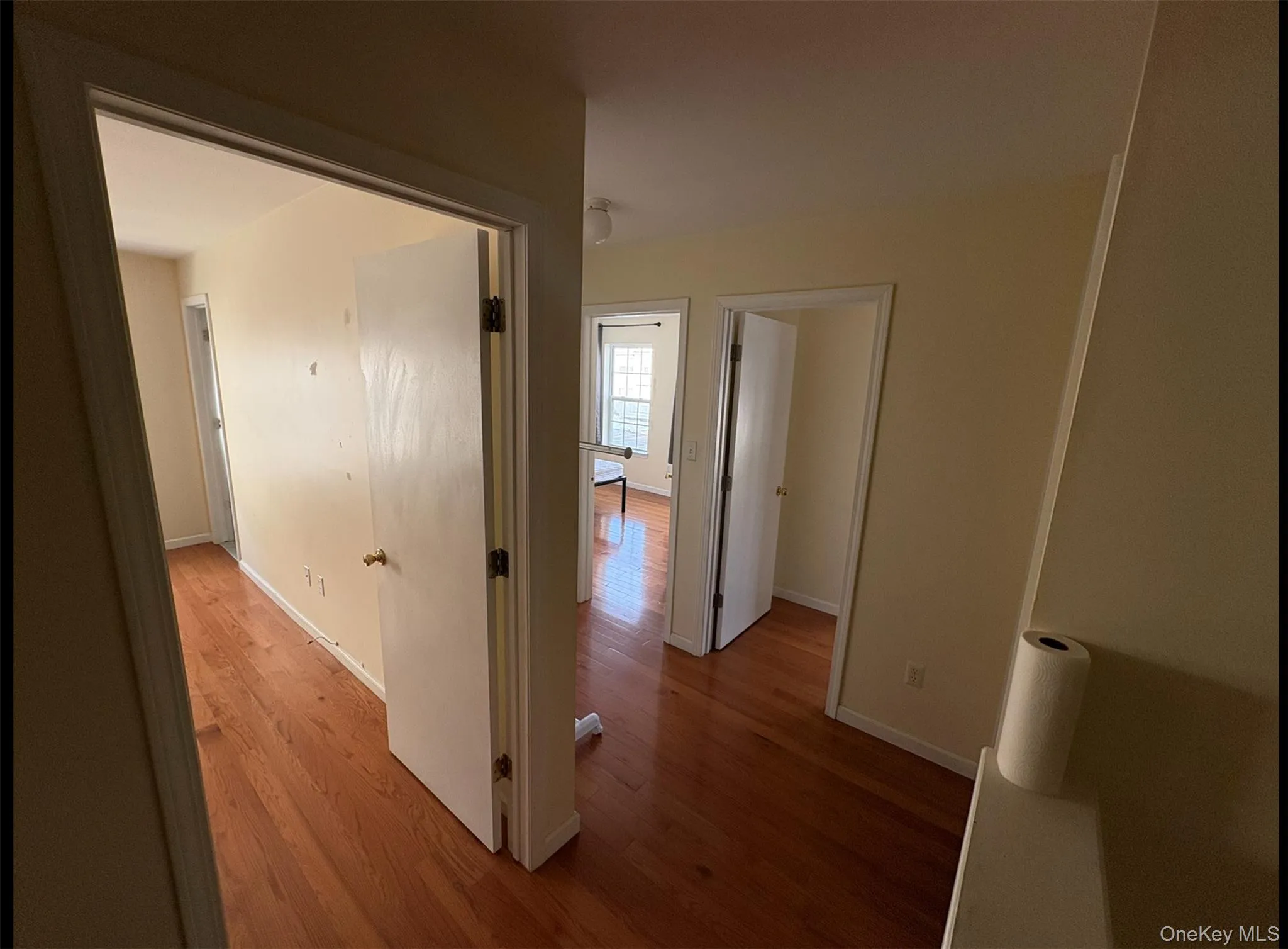 Corridor featuring wood finished floors and baseboards Corridor featuring wood finished floors and baseboards