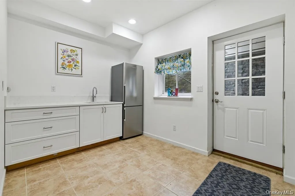 Kitchen featuring white cabinetry, freestanding refrigerator, and recessed lighting Kitchen featuring white cabinetry, freestanding refrigerator, and recessed lighting