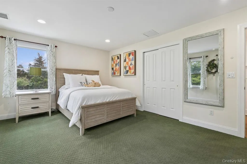 Carpeted bedroom with multiple windows, a closet, and recessed lighting Carpeted bedroom with multiple windows, a closet, and recessed lighting