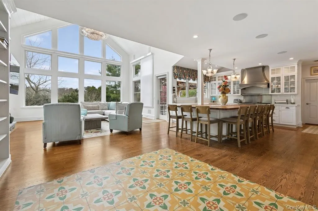 Dining space with a chandelier, dark wood-type flooring, built in shelves, a high ceiling, and recessed lighting Dining space with a chandelier, dark wood-type flooring, built in shelves, a high ceiling, and recessed lighting