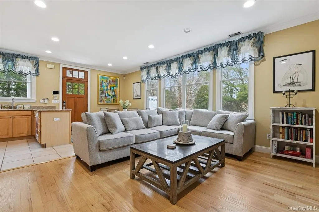 Living room featuring ornamental molding, recessed lighting, and light wood finished floors Living room featuring ornamental molding, recessed lighting, and light wood finished floors