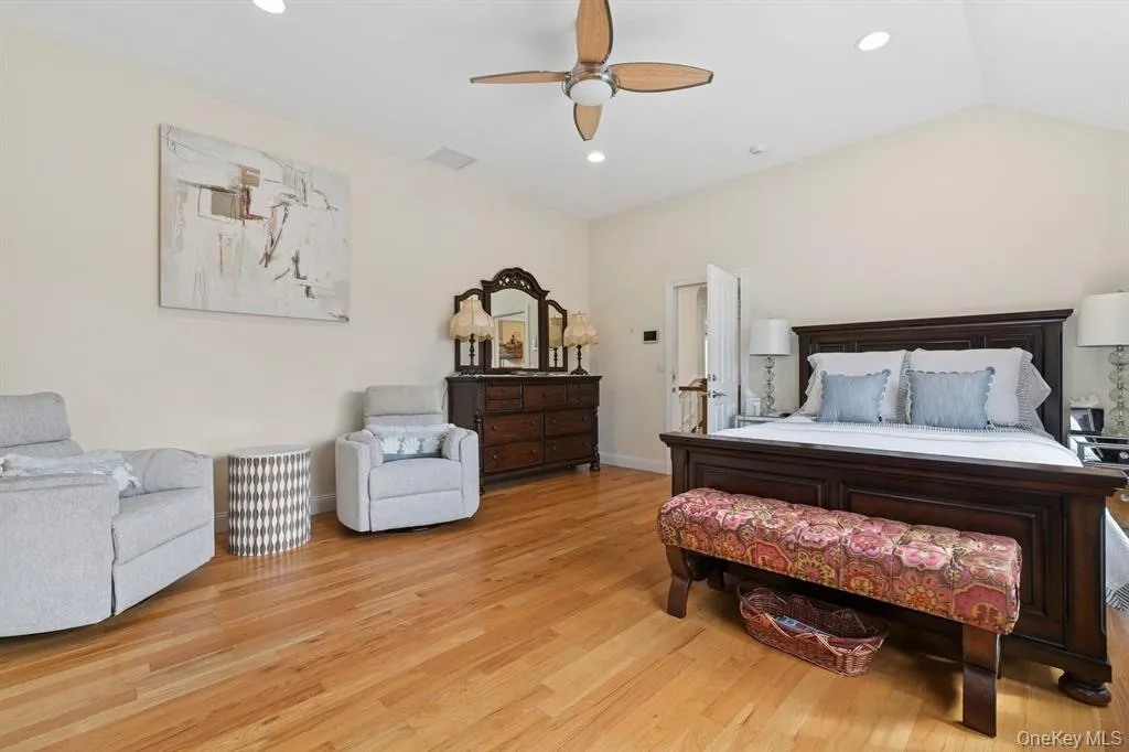 Bedroom featuring light wood-type flooring, a ceiling fan, lofted ceiling, and recessed lighting Bedroom featuring light wood-type flooring, a ceiling fan, lofted ceiling, and recessed lighting