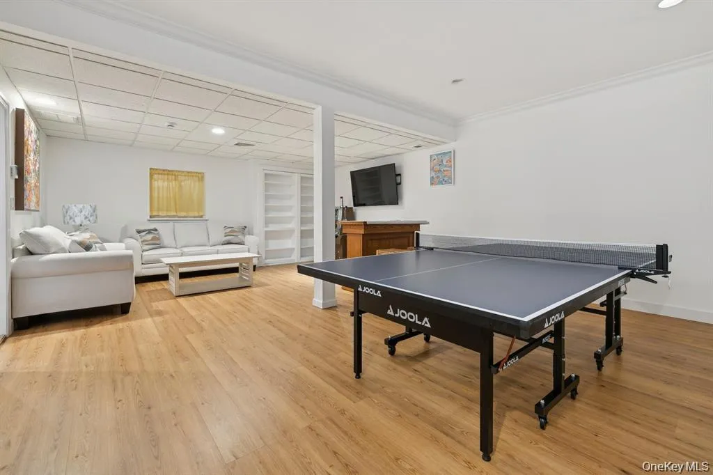 Game room with light wood finished floors, recessed lighting, a drop ceiling, and crown molding Game room with light wood finished floors, recessed lighting, a drop ceiling, and crown molding