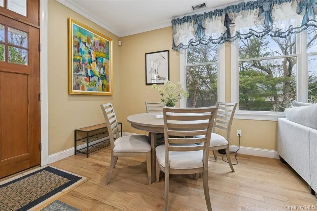 Dining space with light wood finished floors and crown molding Dining space with light wood finished floors and crown molding