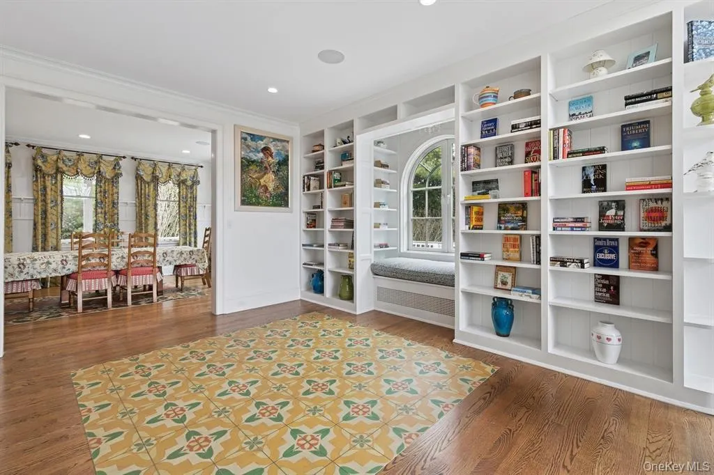 Sitting room with plenty of natural light, built in features, wood finished floors, and crown molding Sitting room with plenty of natural light, built in features, wood finished floors, and crown molding