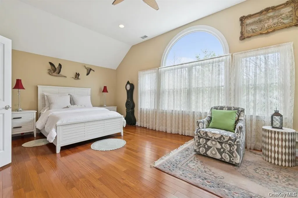 Bedroom featuring vaulted ceiling, wood-type flooring, a ceiling fan, and recessed lighting Bedroom featuring vaulted ceiling, wood-type flooring, a ceiling fan, and recessed lighting