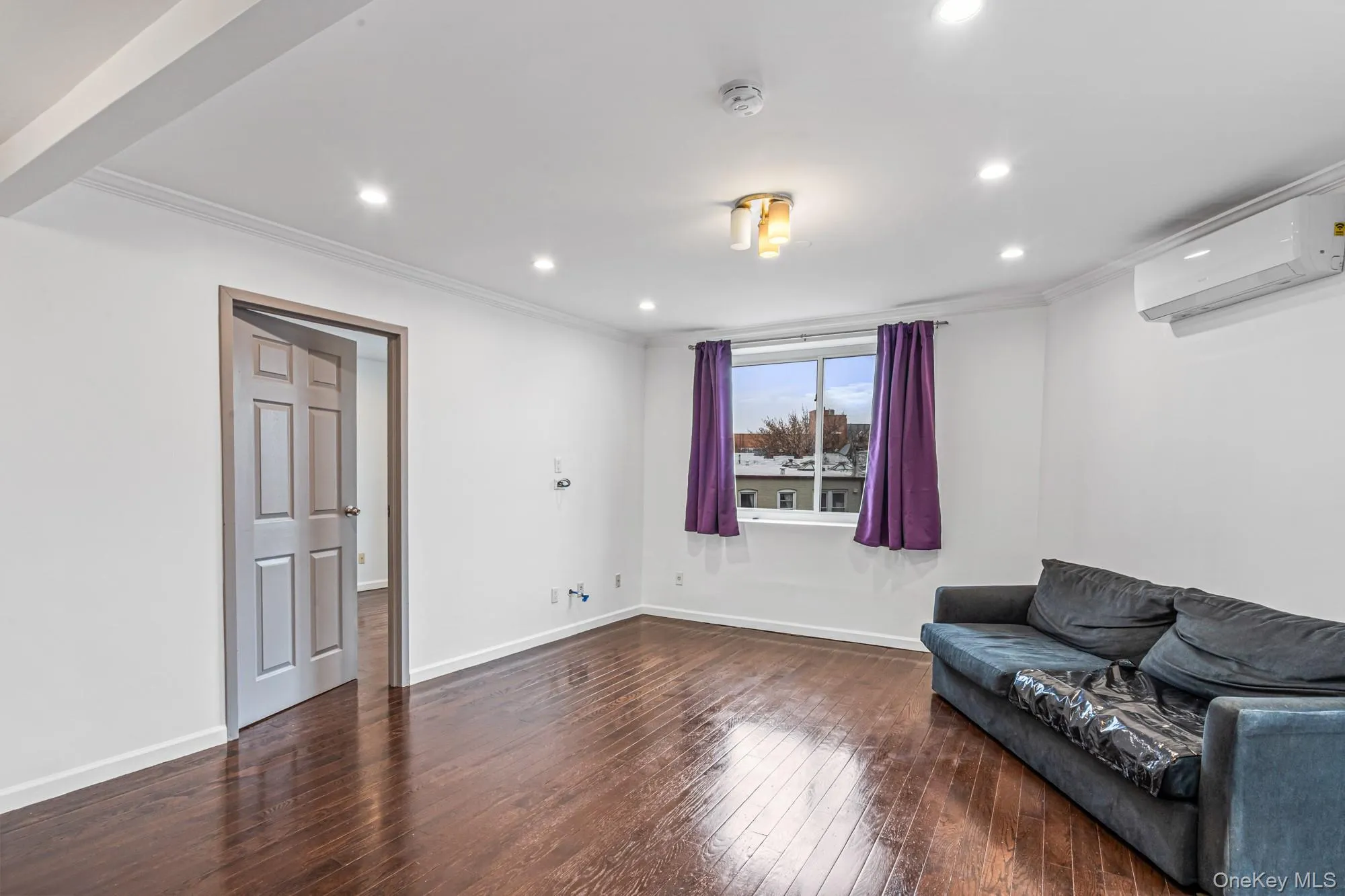 Unfurnished room featuring dark wood-type flooring, ornamental molding, a wall mounted air conditioner, and recessed lighting Unfurnished room featuring dark wood-type flooring, ornamental molding, a wall mounted air conditioner, and recessed lighting