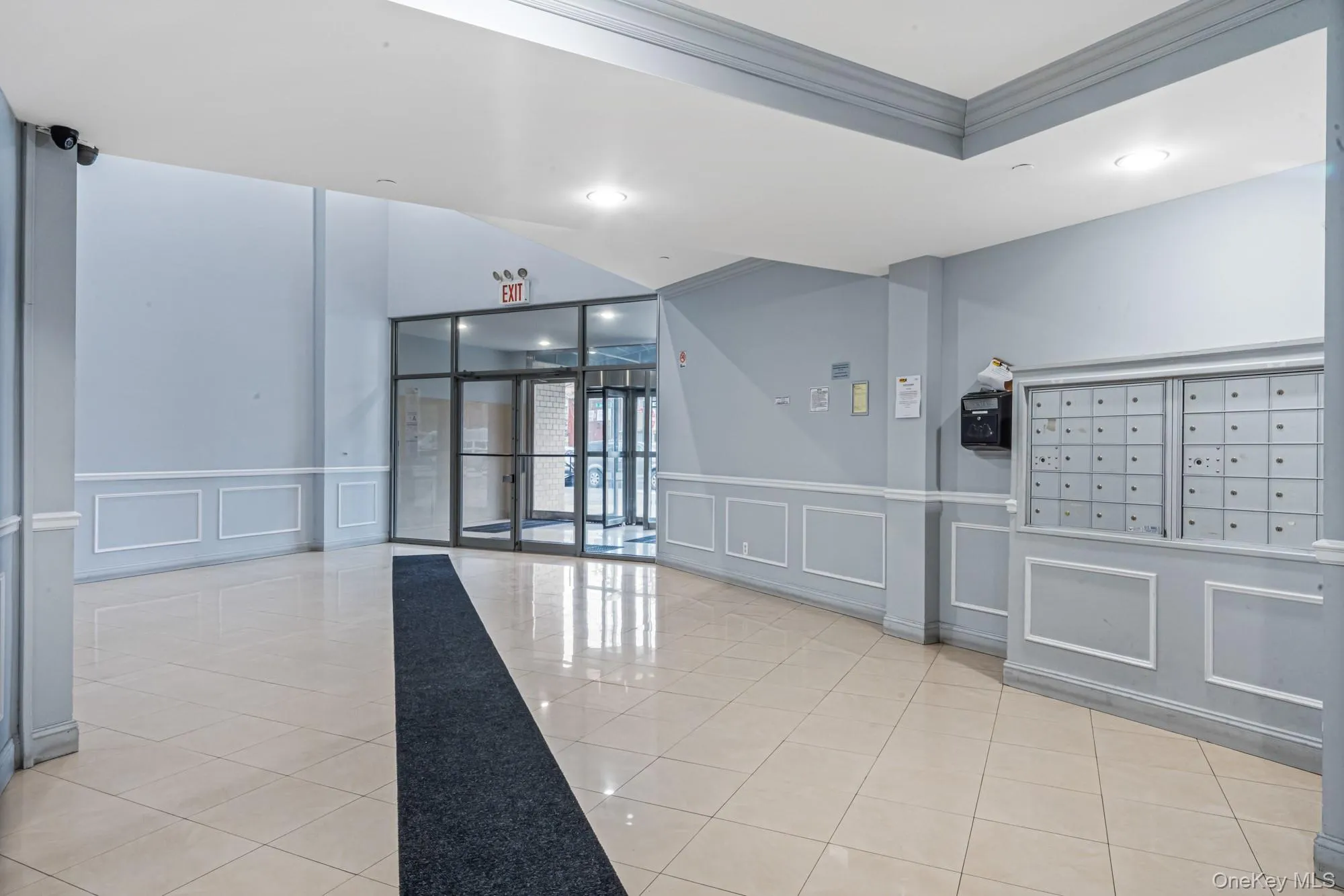 Lobby with a decorative wall, crown molding, and a wainscoted wall Lobby with a decorative wall, crown molding, and a wainscoted wall