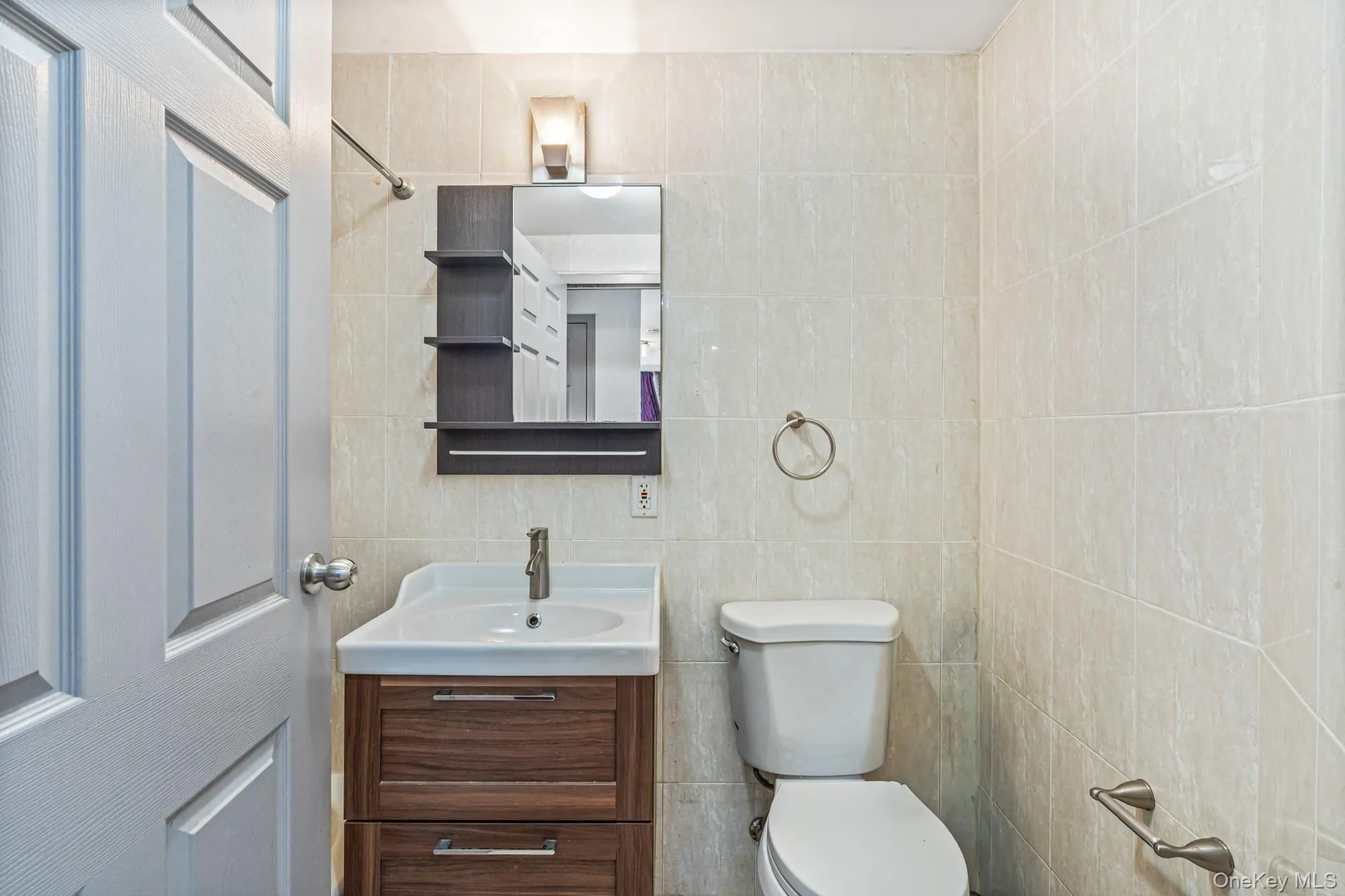Half bathroom with vanity and tile walls Half bathroom with vanity and tile walls