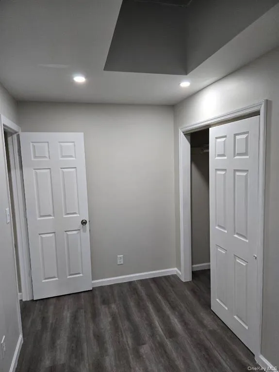 Unfurnished bedroom featuring recessed lighting, dark wood-type flooring, and a closet Unfurnished bedroom featuring recessed lighting, dark wood-type flooring, and a closet