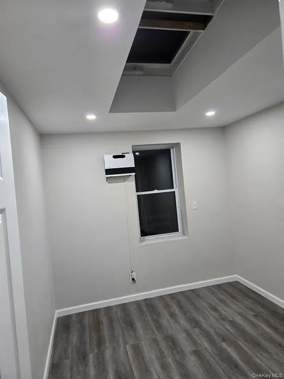 Unfurnished room with dark wood finished floors and recessed lighting Unfurnished room with dark wood finished floors and recessed lighting