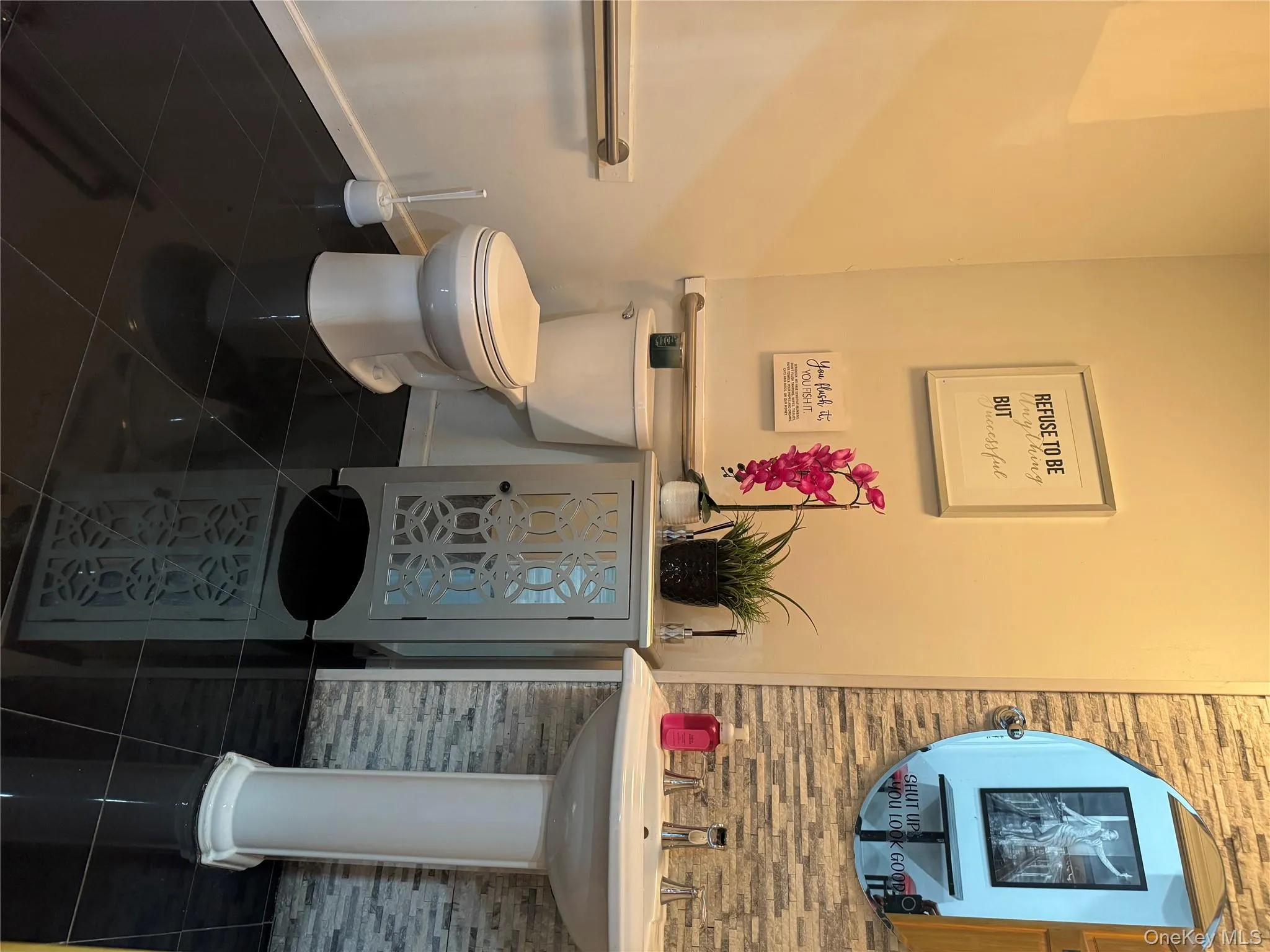 Bathroom with toilet and dark tile patterned flooring Bathroom with toilet and dark tile patterned flooring