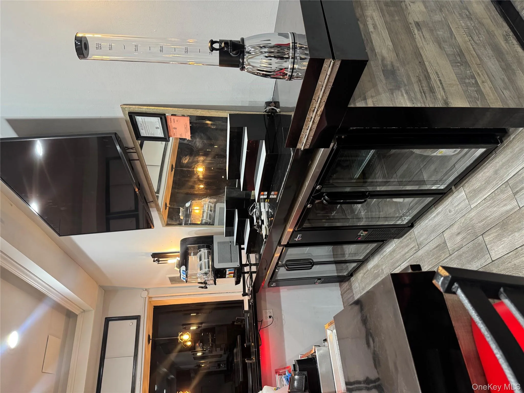 Kitchen with a raised ceiling, ornamental molding, dark countertops, and wood tiled floors Kitchen with a raised ceiling, ornamental molding, dark countertops, and wood tiled floors