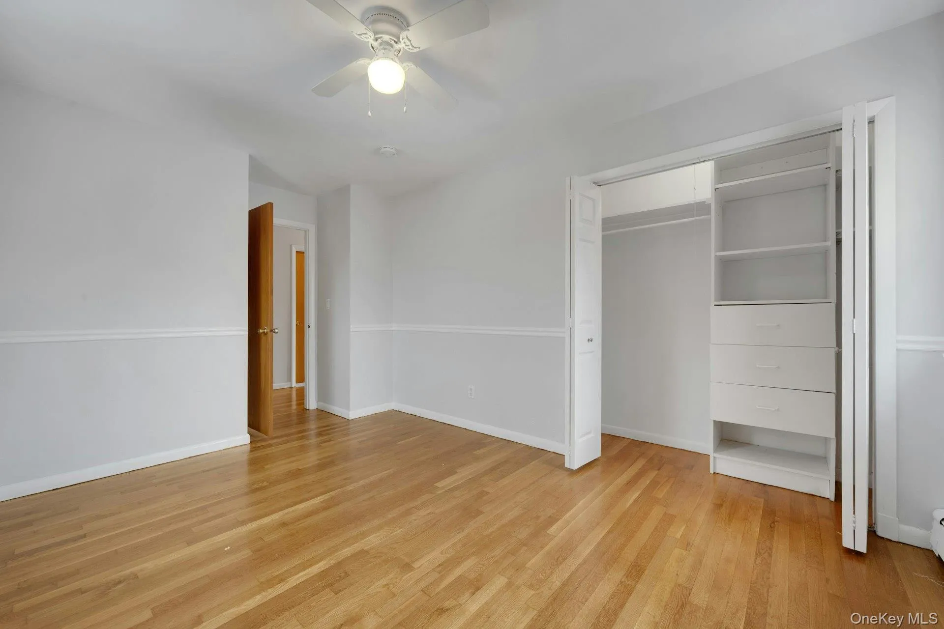 Unfurnished bedroom featuring light wood finished floors, a ceiling fan, and a closet Unfurnished bedroom featuring light wood finished floors, a ceiling fan, and a closet