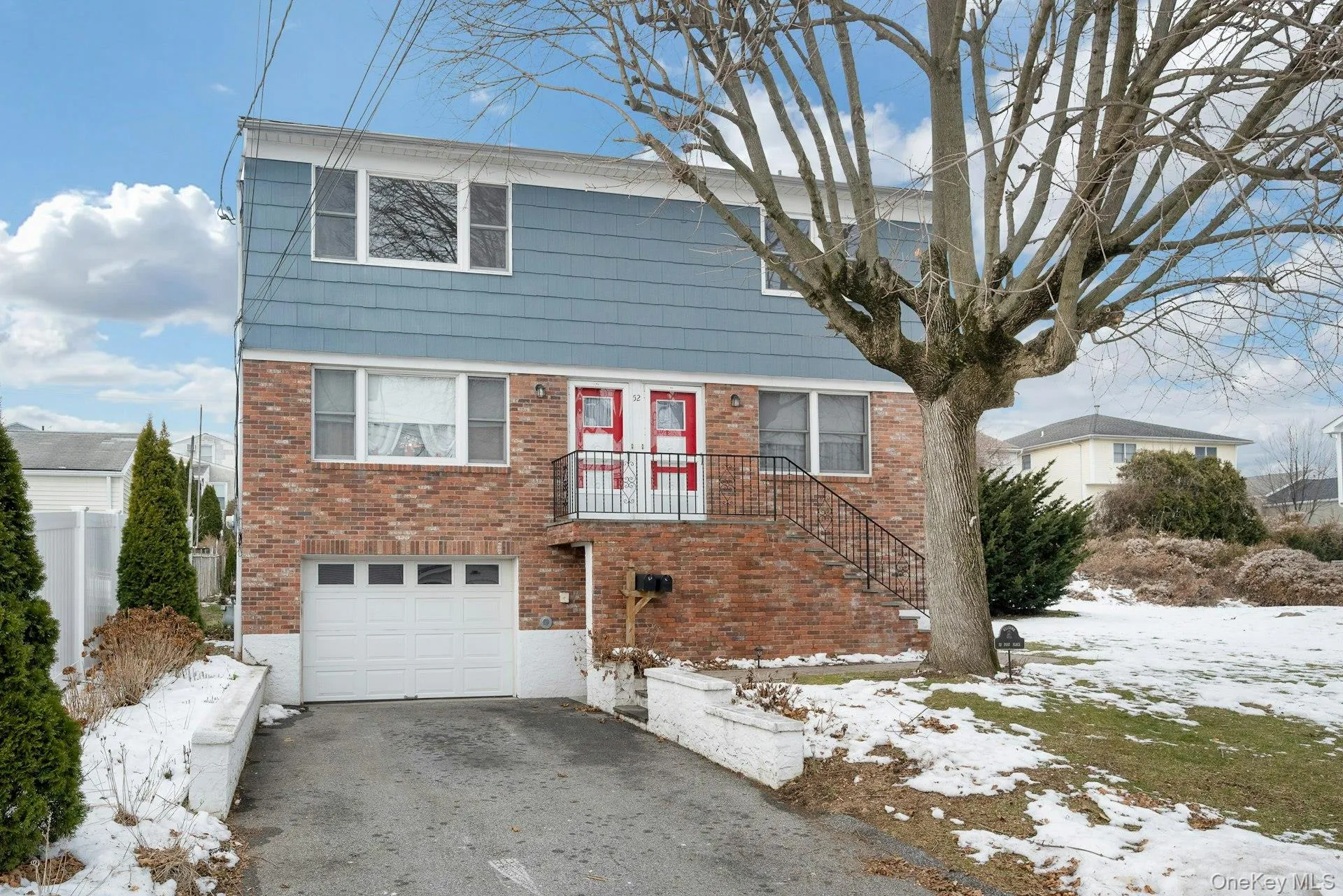 Colonial house featuring brick siding, a garage, and driveway Colonial house featuring brick siding, a garage, and driveway