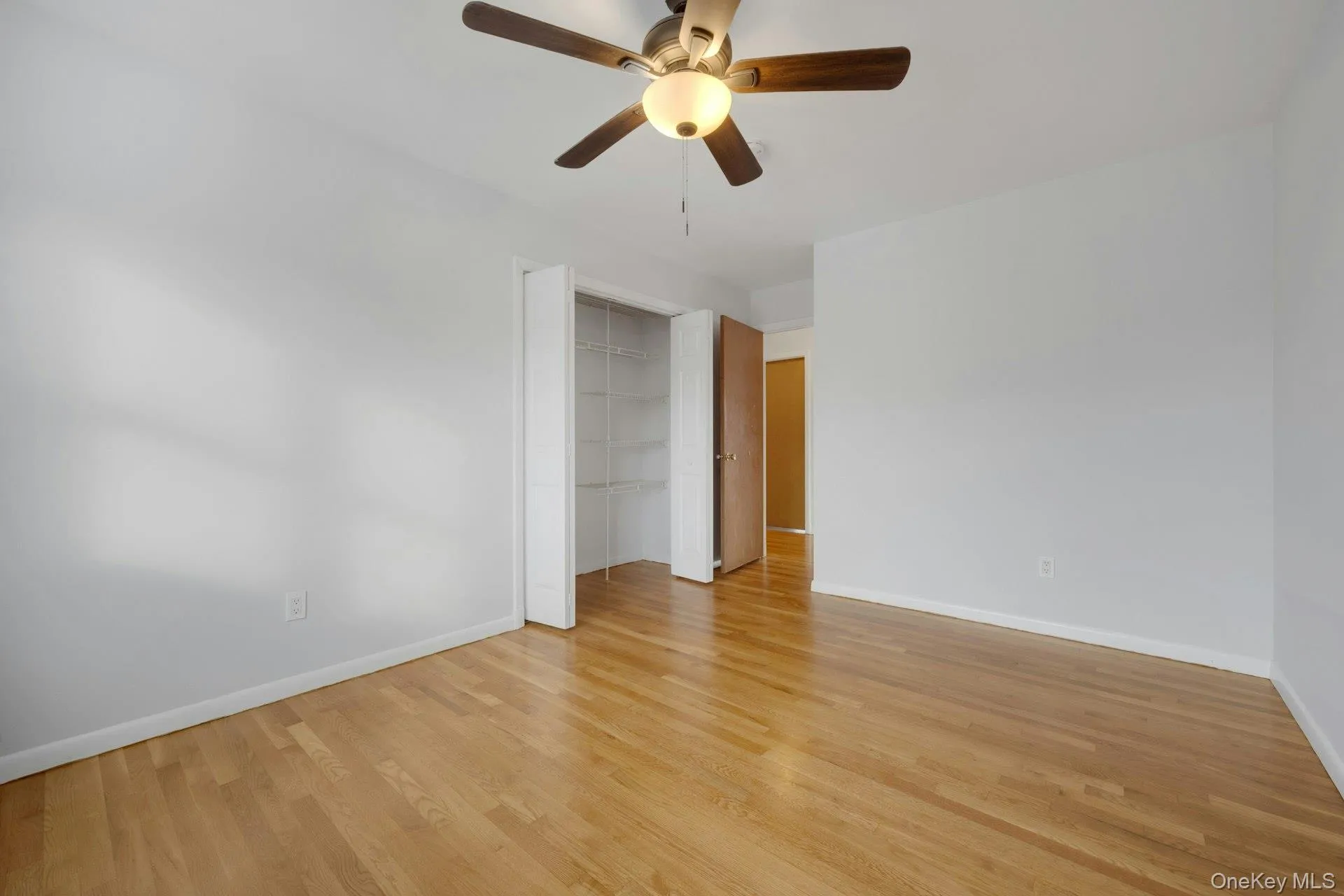 Unfurnished bedroom featuring a ceiling fan, light wood-type flooring, and a closet Unfurnished bedroom featuring a ceiling fan, light wood-type flooring, and a closet