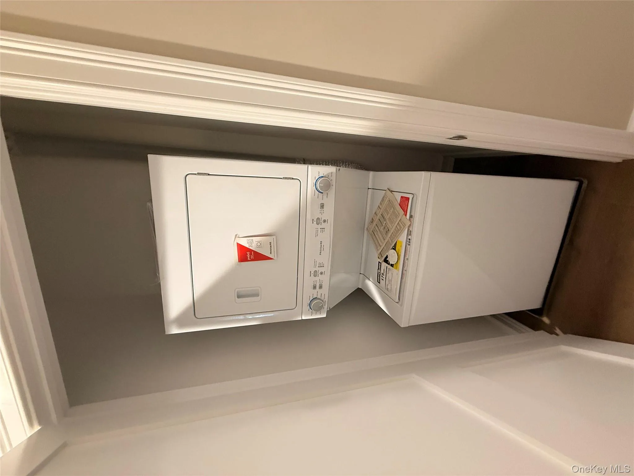 Laundry room featuring stacked washer and clothes dryer and baseboards Laundry room featuring stacked washer and clothes dryer and baseboards