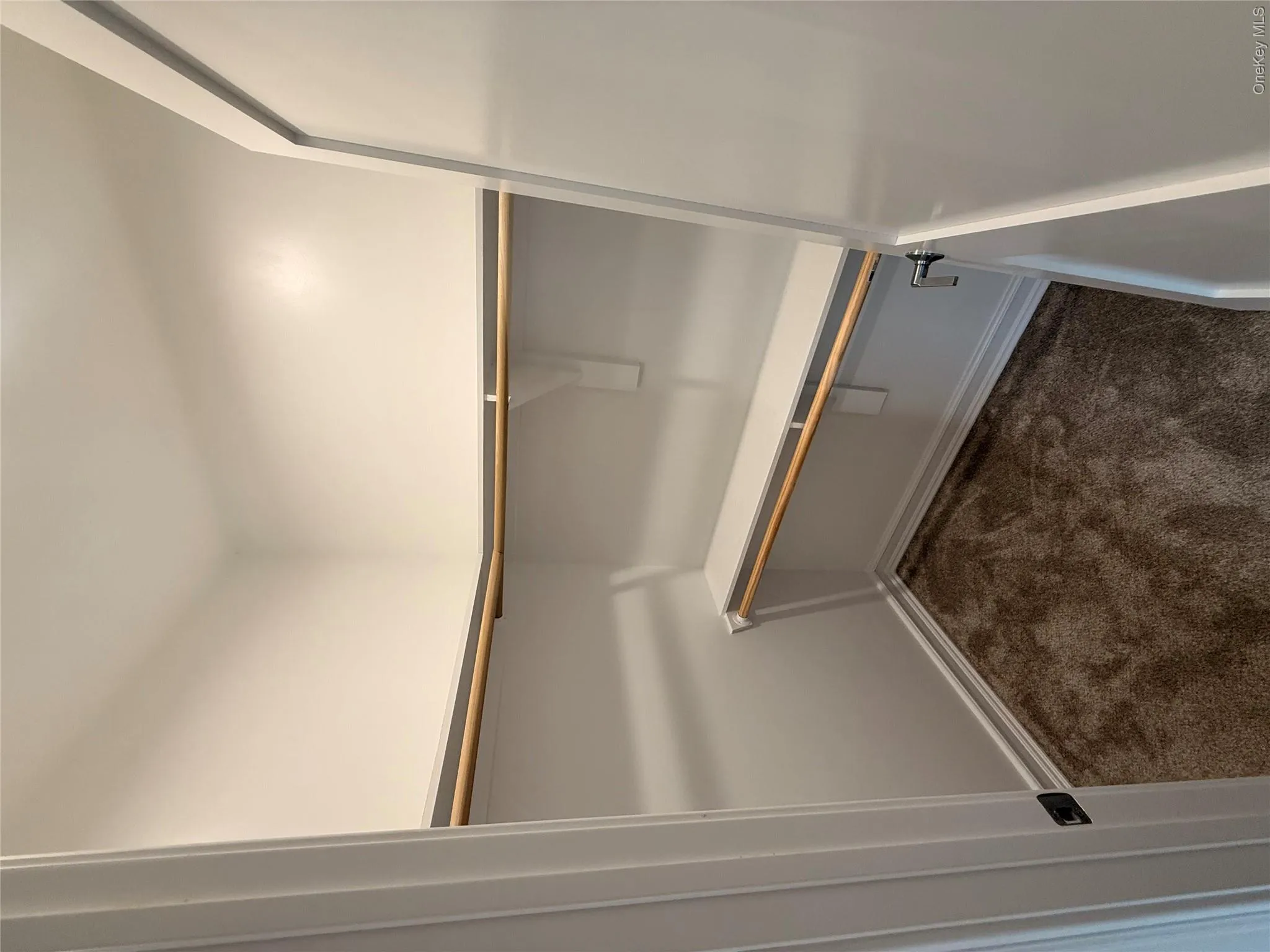 Spacious closet with dark colored carpet Spacious closet with dark colored carpet