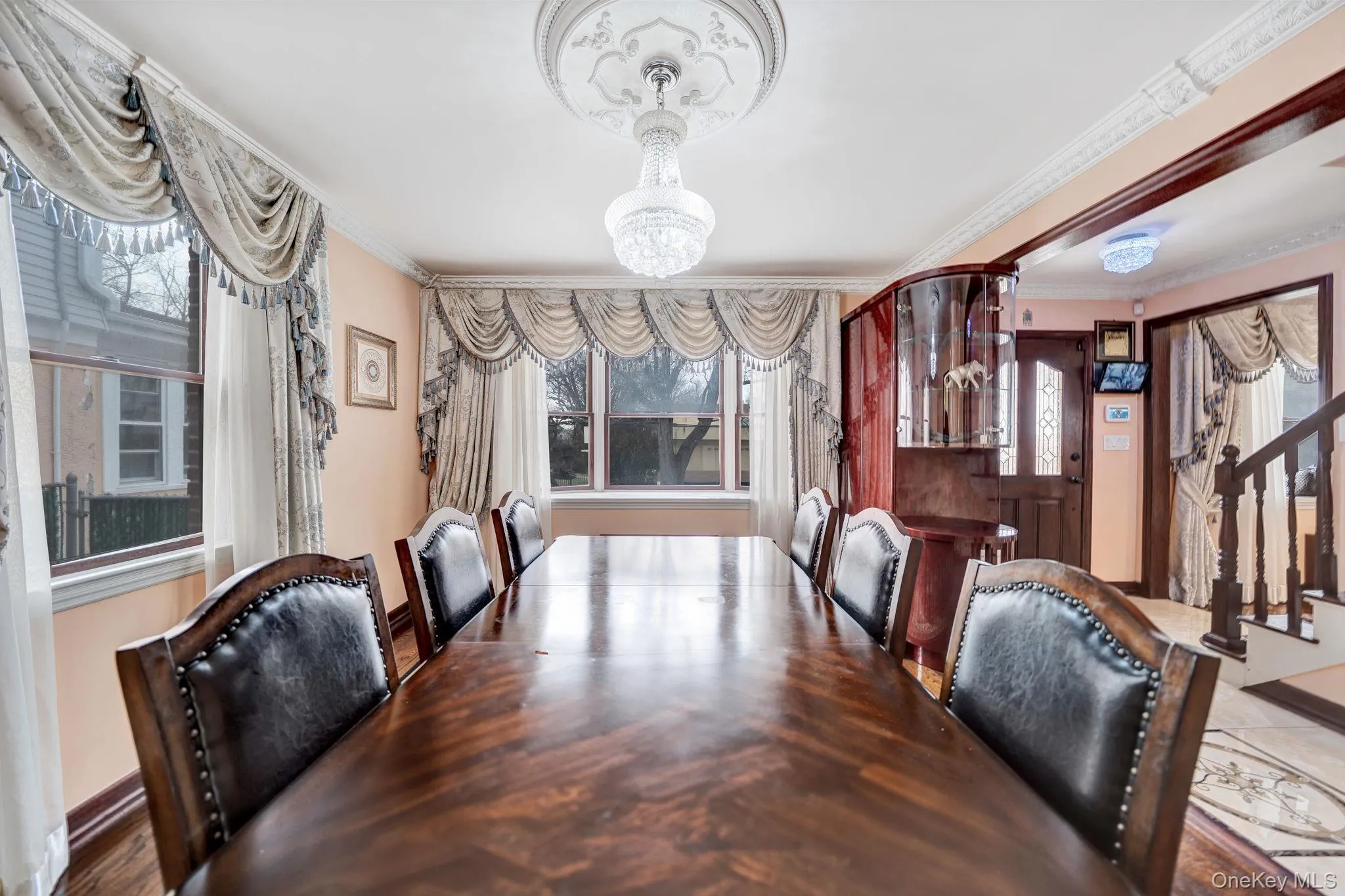 Dining area with crown molding, stairs, and a chandelier Dining area with crown molding, stairs, and a chandelier
