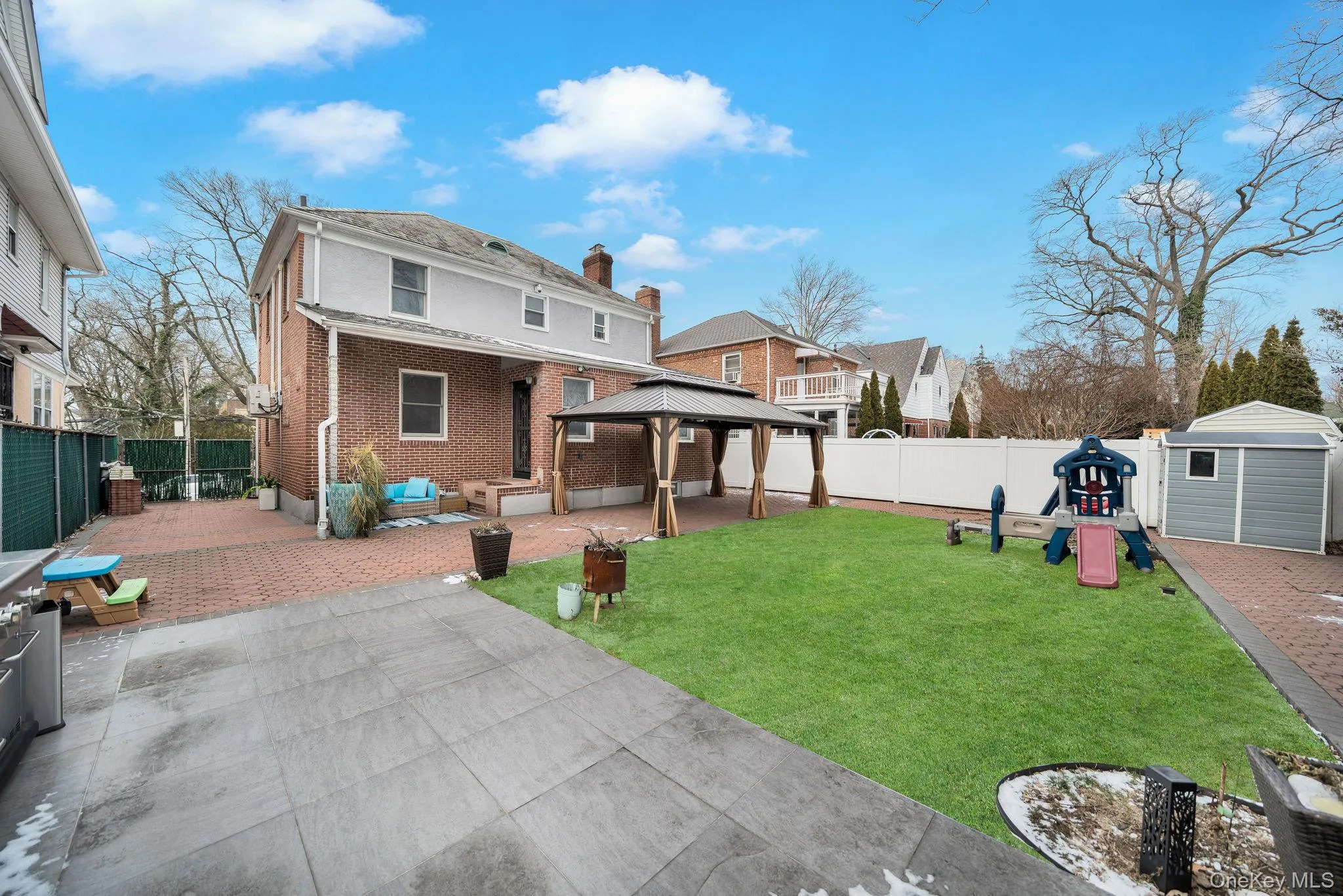 Back of property featuring a patio area, a gazebo, a playground, a fenced backyard, and brick siding Back of property featuring a patio area, a gazebo, a playground, a fenced backyard, and brick siding