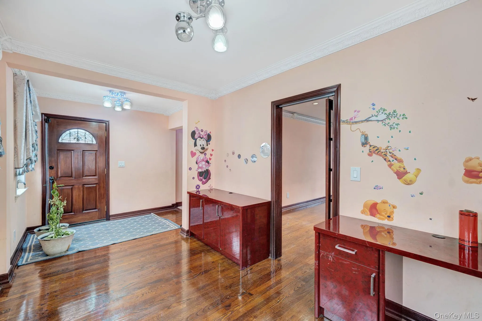 Entryway with ornamental molding, wood-type flooring, and a chandelier Entryway with ornamental molding, wood-type flooring, and a chandelier