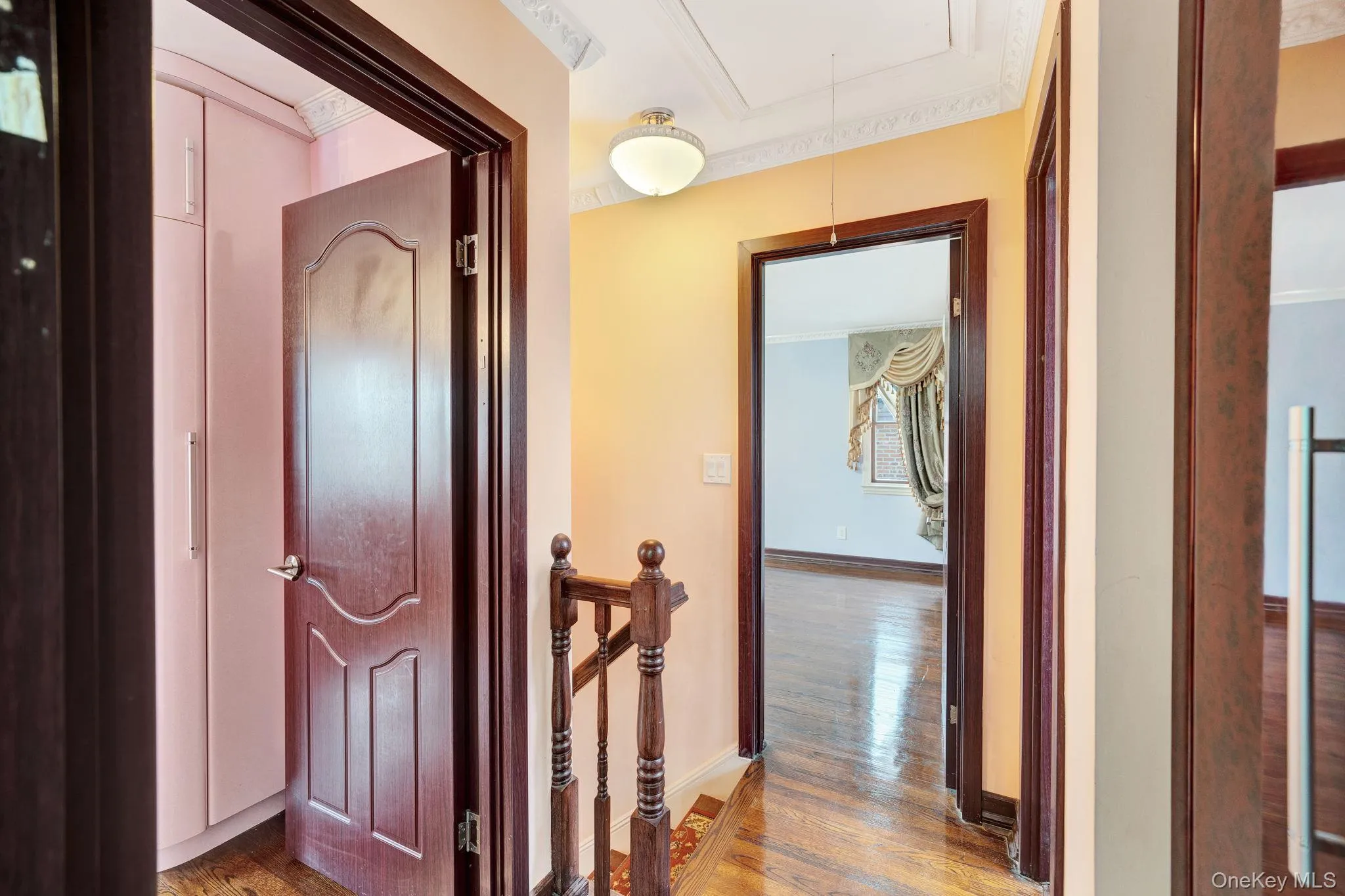 Corridor featuring dark wood-style floors, attic access, and crown molding Corridor featuring dark wood-style floors, attic access, and crown molding
