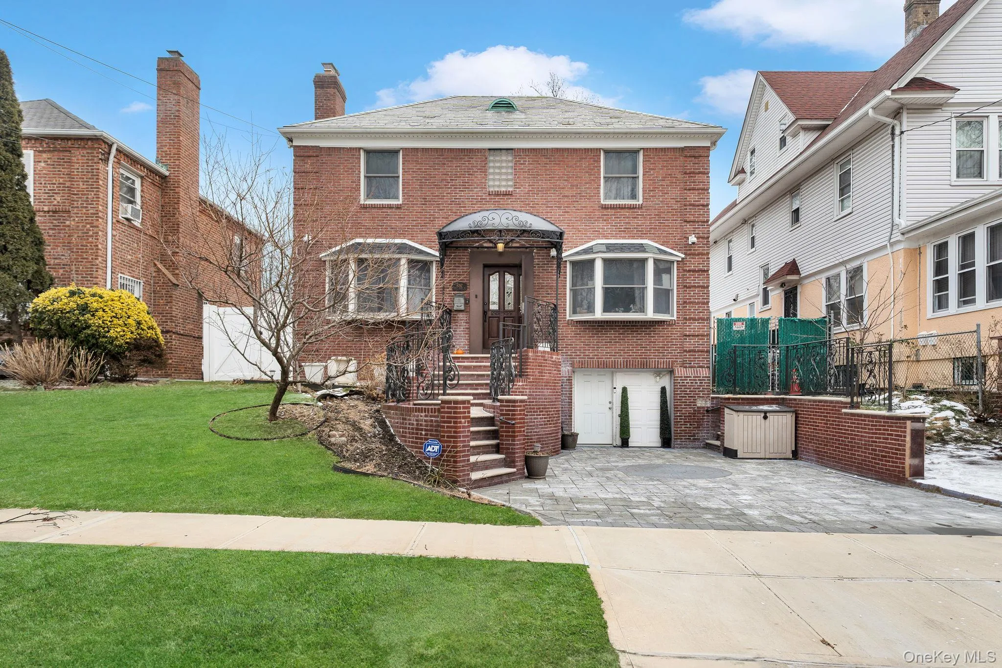 View of front of property featuring brick siding, driveway, and a chimney View of front of property featuring brick siding, driveway, and a chimney