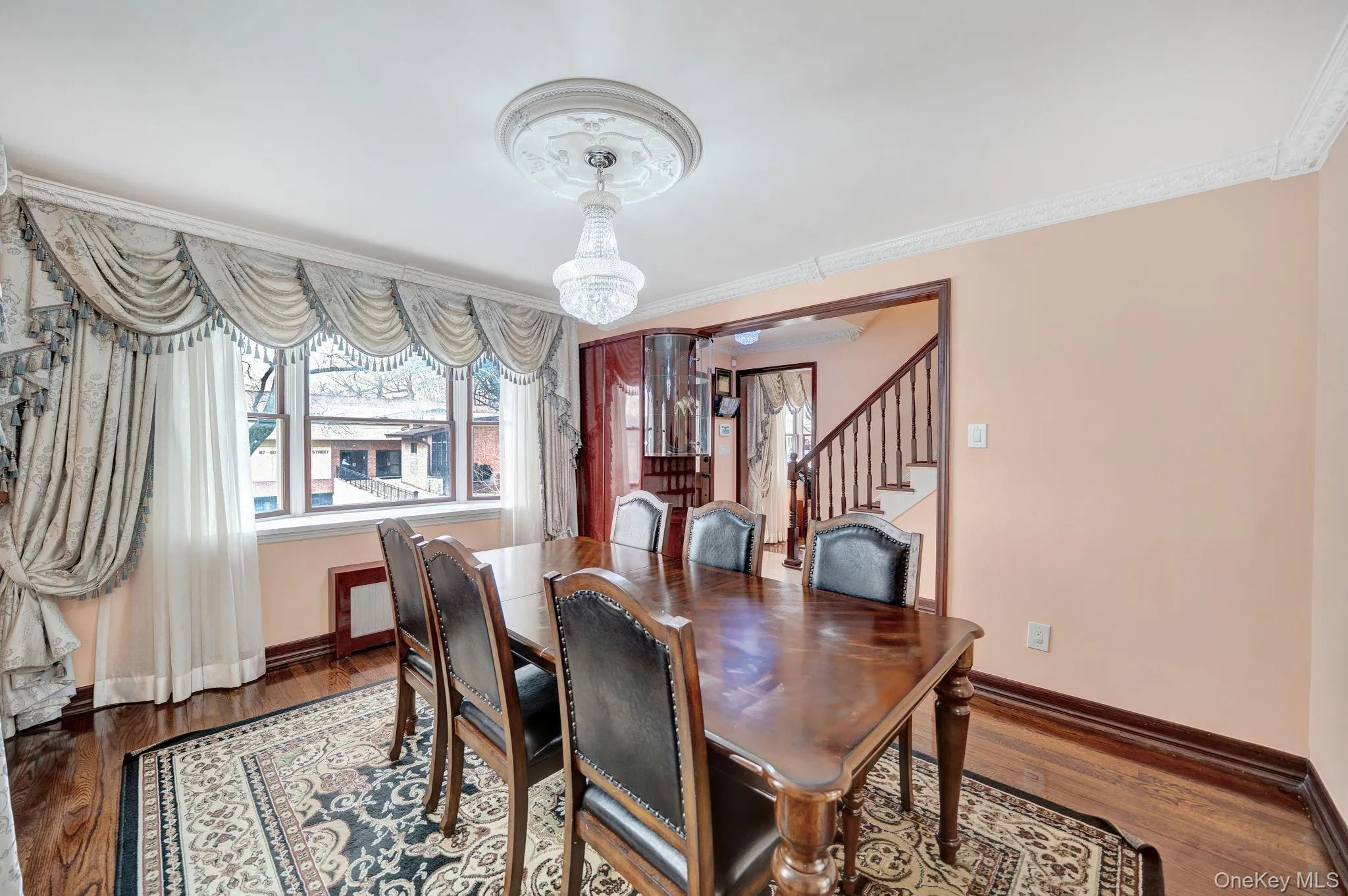 Dining area featuring ornamental molding, wood finished floors, stairway, and a chandelier Dining area featuring ornamental molding, wood finished floors, stairway, and a chandelier