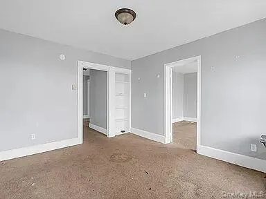 Unfurnished room featuring baseboards and carpet Unfurnished room featuring baseboards and carpet