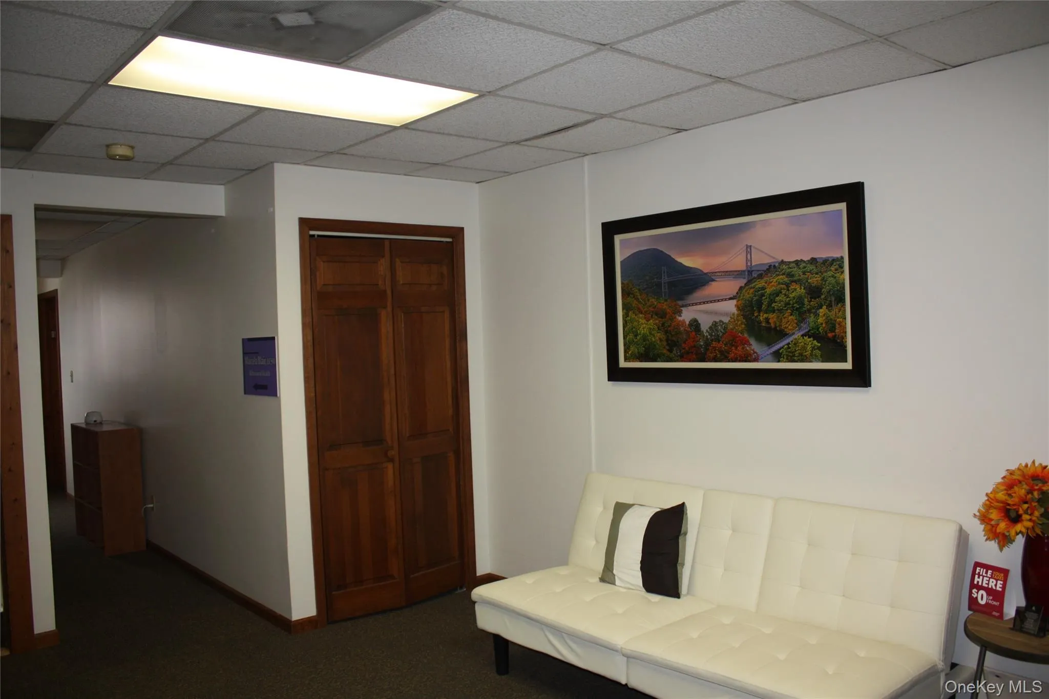 Sitting room featuring dark carpet and a paneled ceiling Sitting room featuring dark carpet and a paneled ceiling